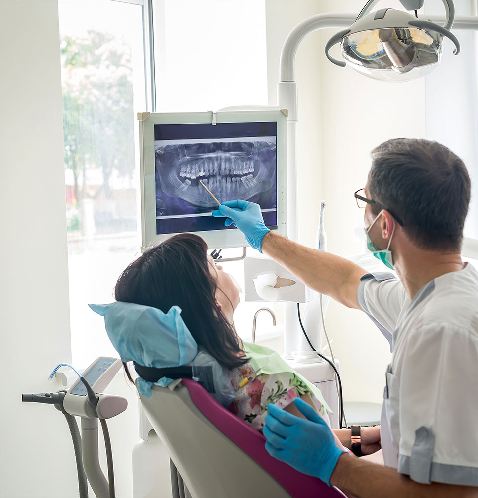 Doctor dentist showing patient's teeth on X-ray